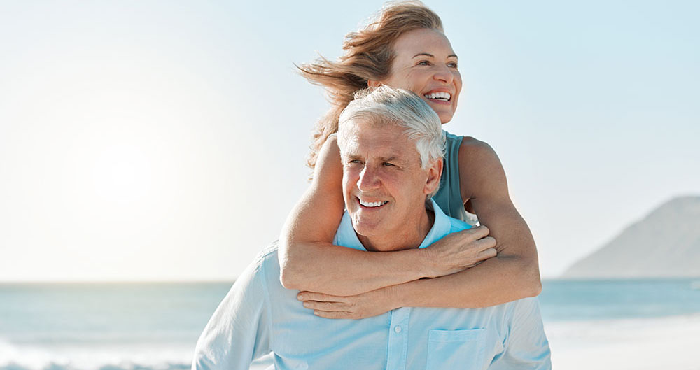 Love, piggyback and walking with old couple at beach for travel destination, summer and anniversary vacation. Relax, tropical and retirement with senior people for holiday, bonding and romance